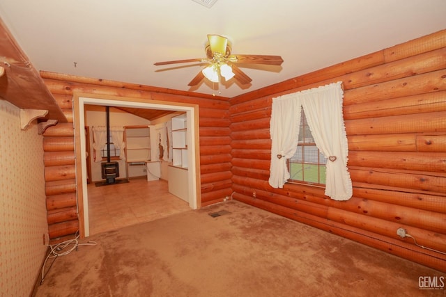 carpeted empty room with log walls and ceiling fan