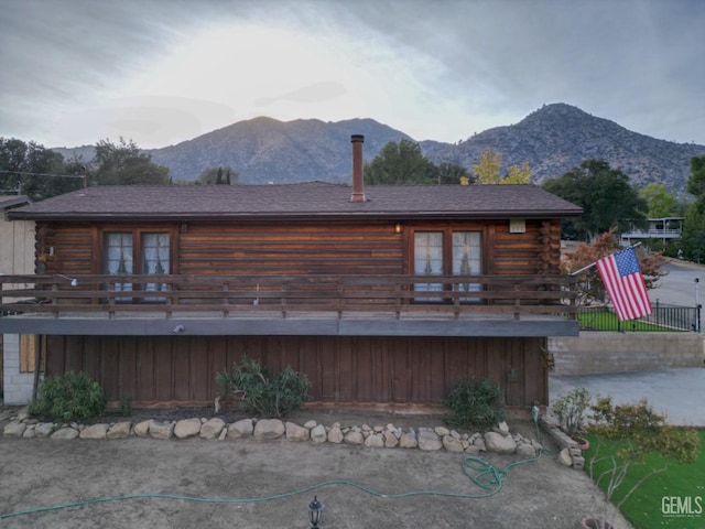 back of property with a deck with mountain view and french doors