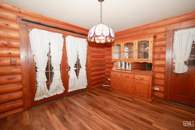 dining area featuring hardwood / wood-style floors and rustic walls