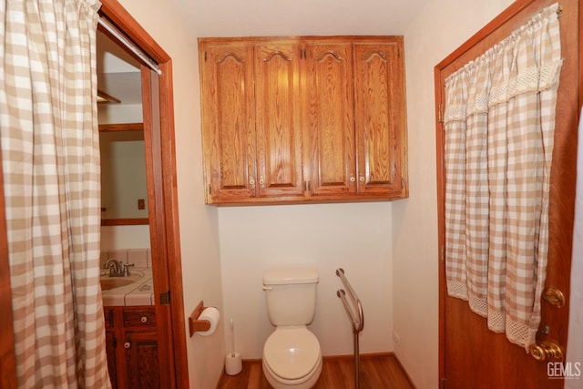 bathroom with wood-type flooring and toilet