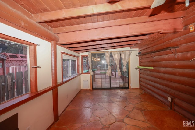 spare room with beam ceiling, rustic walls, and wooden ceiling