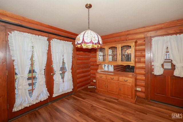 unfurnished dining area with dark hardwood / wood-style floors and rustic walls