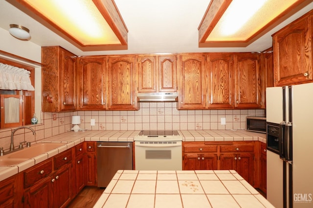 kitchen with tasteful backsplash, tile countertops, and white appliances