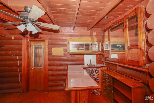 kitchen featuring wood ceiling, sink, log walls, tile countertops, and beamed ceiling