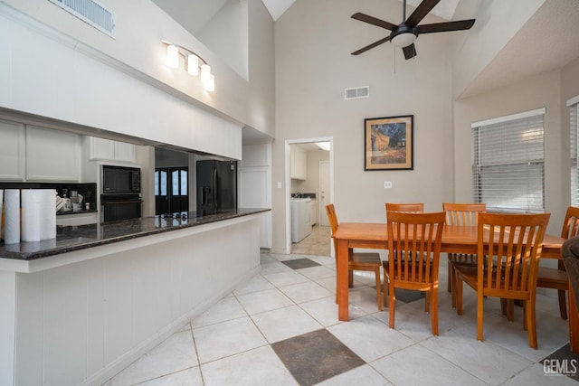 dining area with washing machine and dryer, ceiling fan, high vaulted ceiling, and light tile patterned flooring