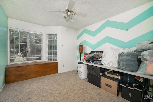 carpeted bedroom with a textured ceiling and ceiling fan