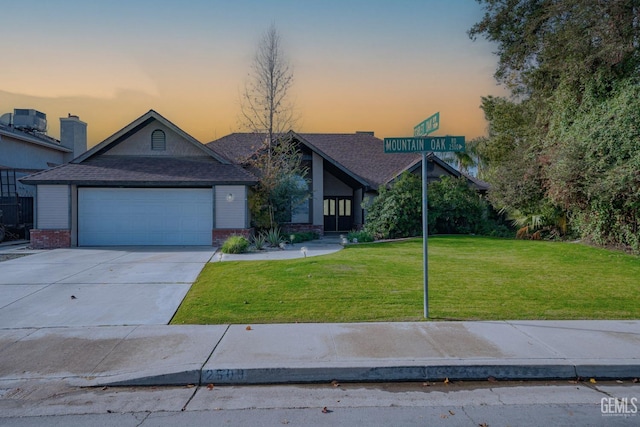 view of front of property featuring a yard, a garage, and cooling unit