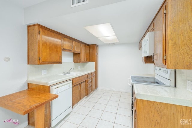 kitchen featuring sink, white appliances, decorative backsplash, and light tile patterned flooring