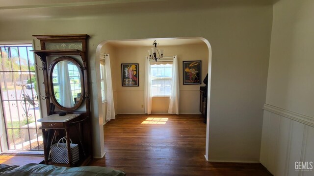 2617 4th St, Bakersfield, CA 93304 - entryway featuring arched walkways, a chandelier, dark wood-style floors, and wainscoting