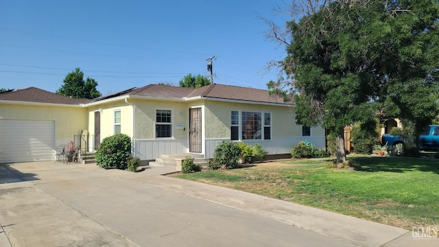 2617 4th St, Bakersfield, CA 93304 - view of front of house featuring a garage, driveway, a front yard, stucco siding, and solar panels