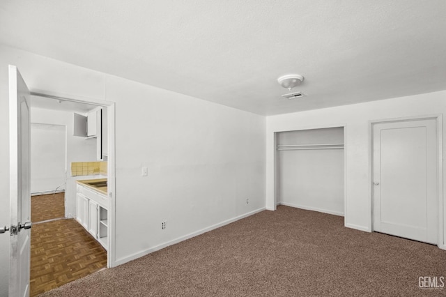 unfurnished bedroom featuring dark parquet floors and a textured ceiling