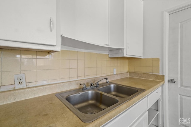 kitchen with white cabinets, sink, and backsplash