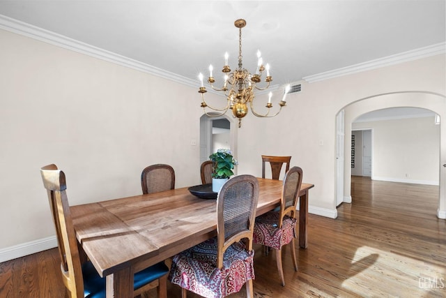 3025 19th St, Bakersfield, CA 93301 - dining space featuring crown molding, an inviting chandelier, baseboards, arched walkways, and wood finished floors