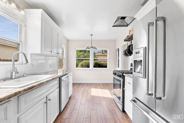 3025 19th St, Bakersfield, CA 93301 - kitchen featuring decorative backsplash, appliances with stainless steel finishes, white cabinetry, a sink, and light wood-style floors