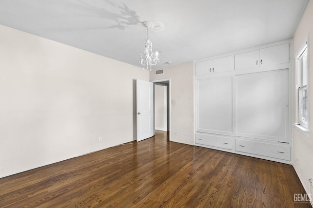 3025 19th St, Bakersfield, CA 93301 - unfurnished bedroom with a notable chandelier, dark wood-type flooring, a closet, and visible vents