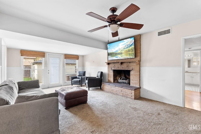 3025 19th St, Bakersfield, CA 93301 - living room with carpet floors, ceiling fan, wainscoting, and a brick fireplace