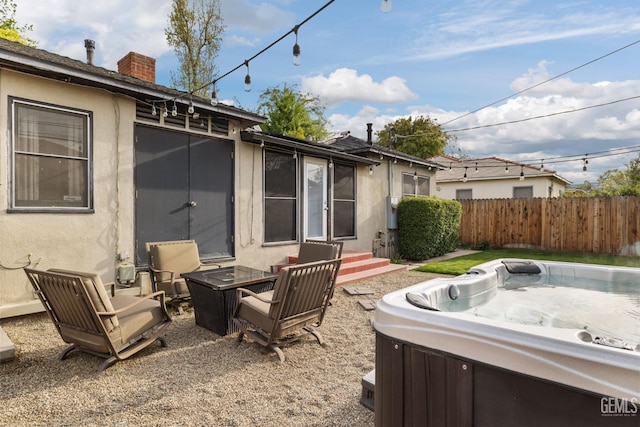 3025 19th St, Bakersfield, CA 93301 - view of patio featuring a hot tub, fence, and entry steps