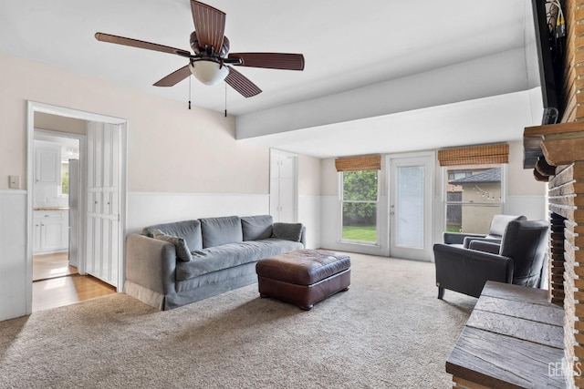 3025 19th St, Bakersfield, CA 93301 - carpeted living area with a wainscoted wall, ceiling fan, and a brick fireplace