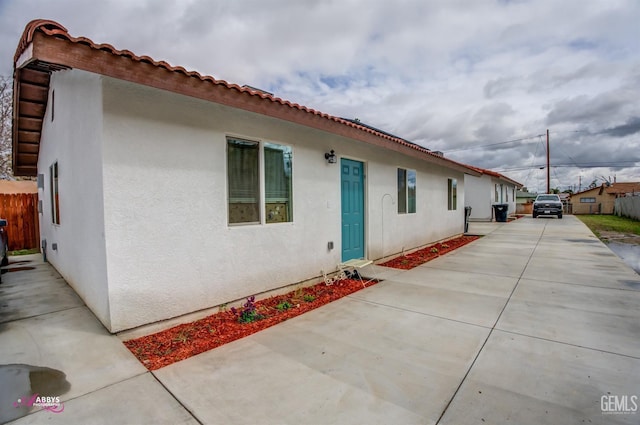 back of house featuring stucco siding and fence