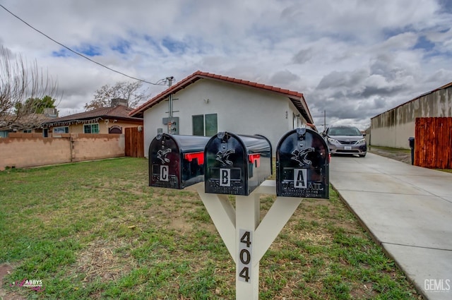 view of front of property with fence, stucco siding, a front lawn, concrete driveway, and a tile roof