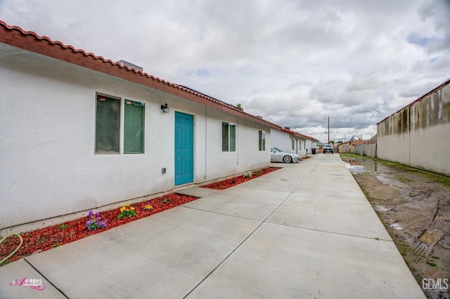 view of home's exterior featuring stucco siding and fence