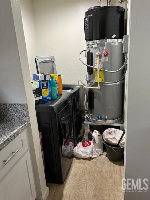 utility room with washer and clothes dryer and heat pump water heater