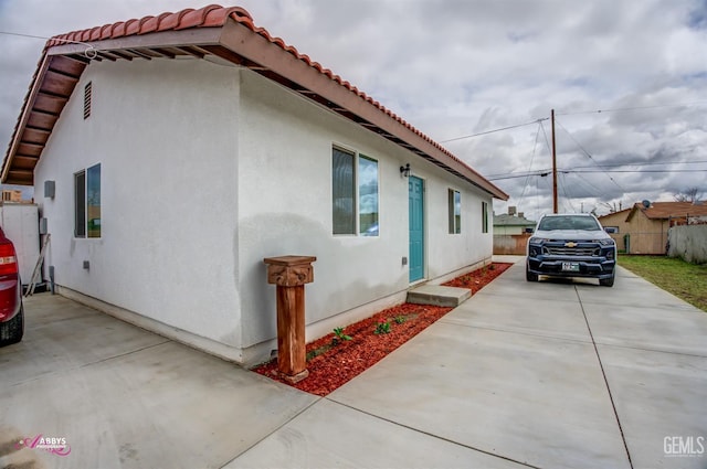 view of home's exterior featuring a patio area, stucco siding, and fence