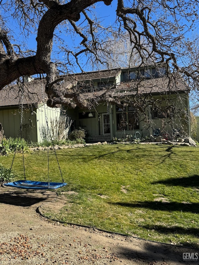 rear view of property with a lawn