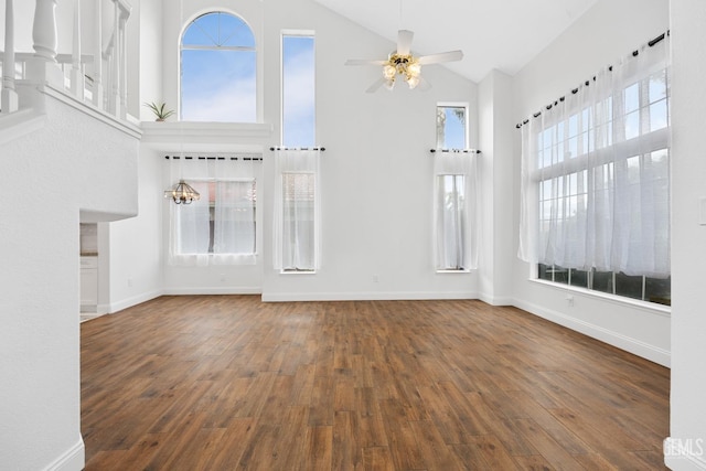 unfurnished living room featuring a wealth of natural light, ceiling fan, dark hardwood / wood-style flooring, and high vaulted ceiling