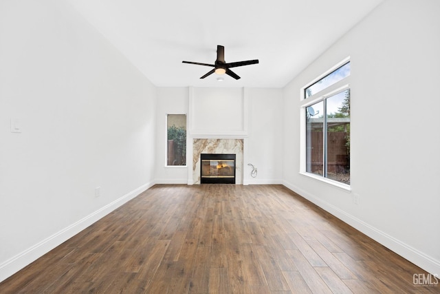 unfurnished living room featuring ceiling fan and dark hardwood / wood-style flooring