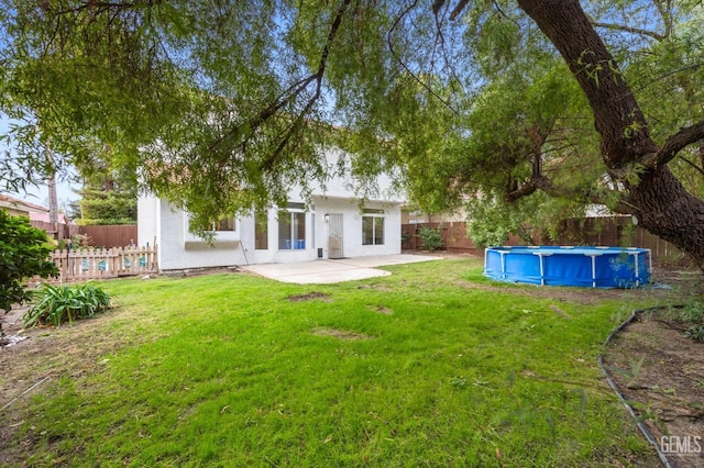 view of yard featuring a fenced in pool and a patio