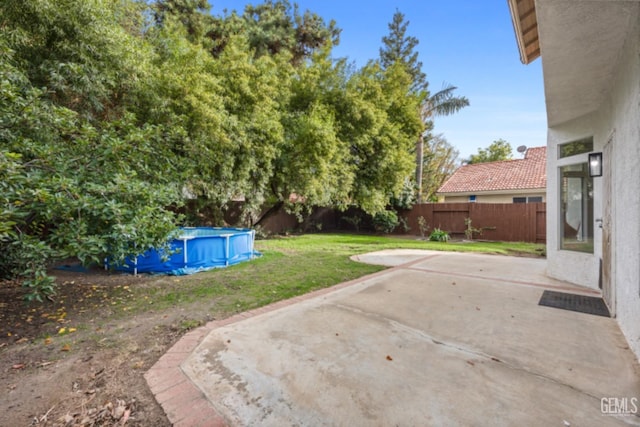 view of yard with a fenced in pool and a patio area