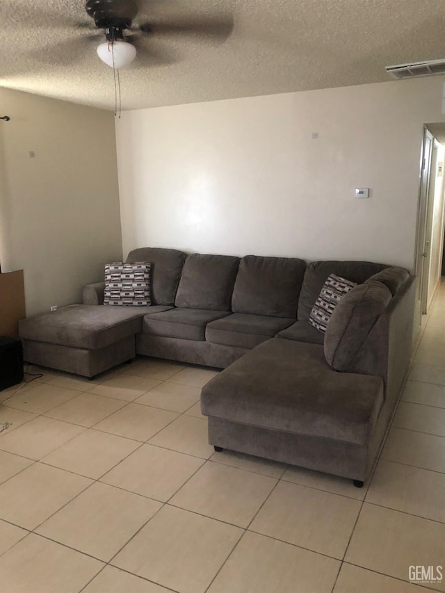 living room with light tile patterned floors, ceiling fan, a textured ceiling, and visible vents