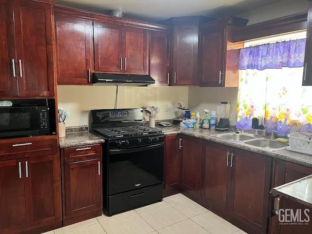 kitchen featuring tile patterned flooring, a sink, black appliances, reddish brown cabinets, and under cabinet range hood