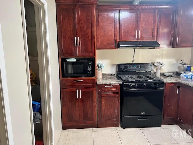 kitchen featuring dark brown cabinets, light stone counters, black appliances, under cabinet range hood, and light tile patterned flooring