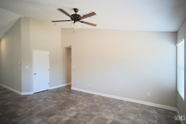 unfurnished room featuring lofted ceiling, plenty of natural light, and baseboards