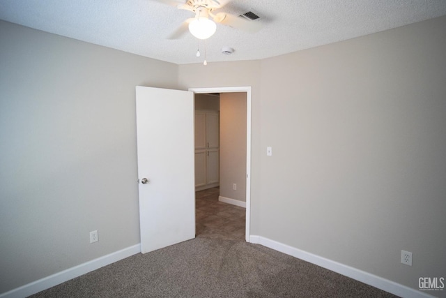 unfurnished room featuring visible vents, carpet flooring, ceiling fan, a textured ceiling, and baseboards