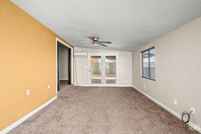 carpeted spare room featuring ceiling fan, a wall mounted AC, and a textured ceiling