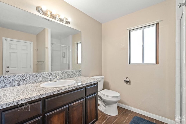 bathroom featuring vanity, toilet, a shower with shower door, and hardwood / wood-style floors