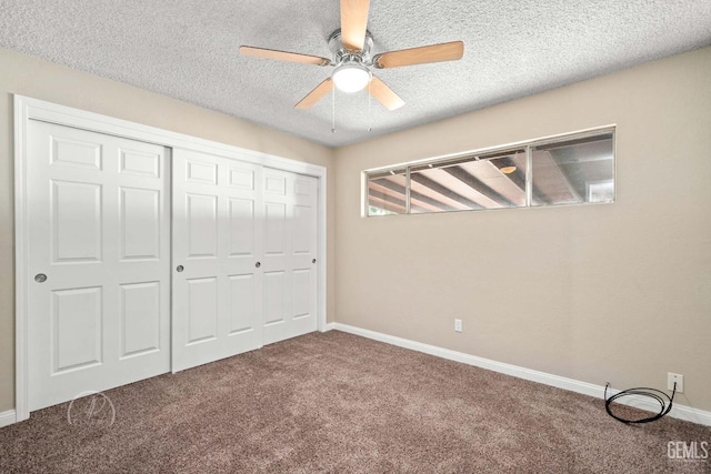 unfurnished bedroom featuring ceiling fan, a closet, a textured ceiling, and carpet flooring