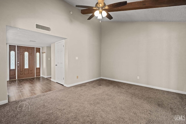 entryway with dark colored carpet, ceiling fan, and a textured ceiling