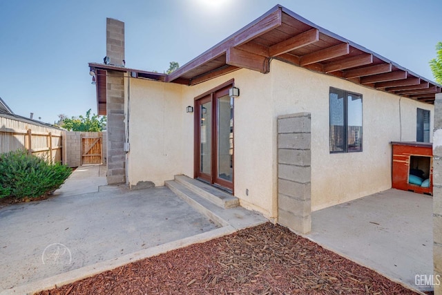 view of exterior entry with a patio area