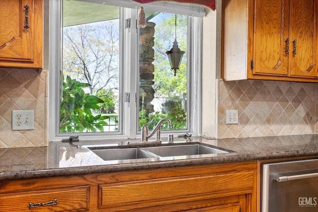 7858 Stine Rd, Bakersfield, CA 93313 - kitchen featuring a sink, backsplash, brown cabinetry, and a wealth of natural light