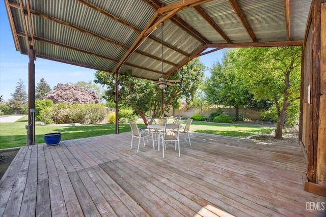 7858 Stine Rd, Bakersfield, CA 93313 - wooden deck with outdoor dining area, a fenced backyard, and a lawn