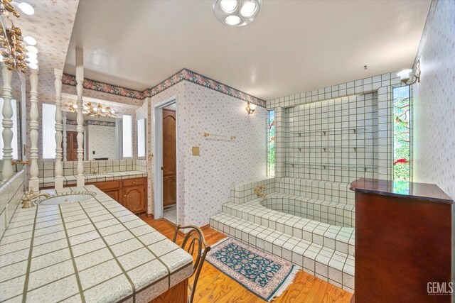 7858 Stine Rd, Bakersfield, CA 93313 - full bathroom with two vanities, a garden tub, wallpapered walls, and wood finished floors