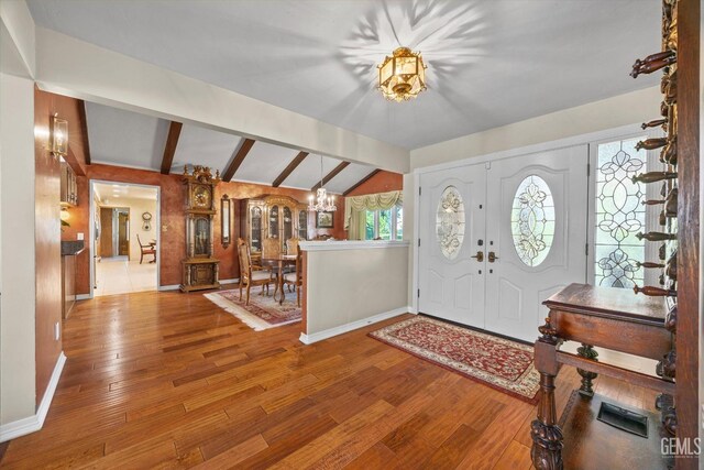 7858 Stine Rd, Bakersfield, CA 93313 - entryway with lofted ceiling with beams, wood finished floors, an inviting chandelier, and baseboards