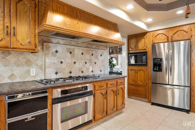 7858 Stine Rd, Bakersfield, CA 93313 - kitchen with light tile patterned flooring, appliances with stainless steel finishes, custom range hood, and dark countertops