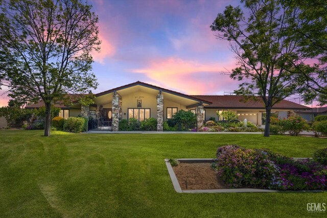 7858 Stine Rd, Bakersfield, CA 93313 - view of front of home featuring a front yard, an attached garage, and stone siding