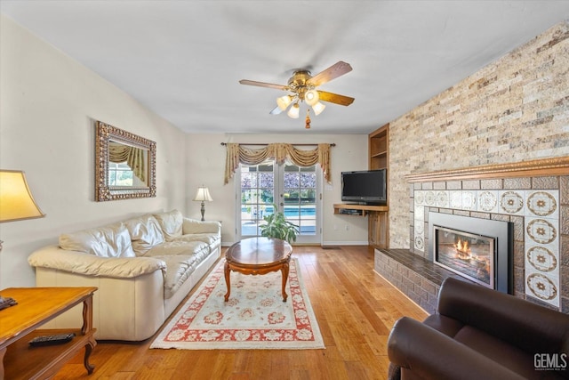 7858 Stine Rd, Bakersfield, CA 93313 - living area featuring baseboards, a ceiling fan, wood finished floors, and a fireplace