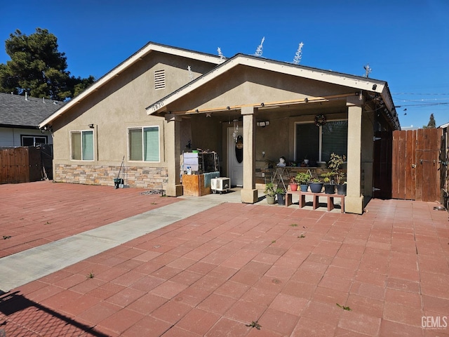 back of house featuring a wooden deck and a patio area